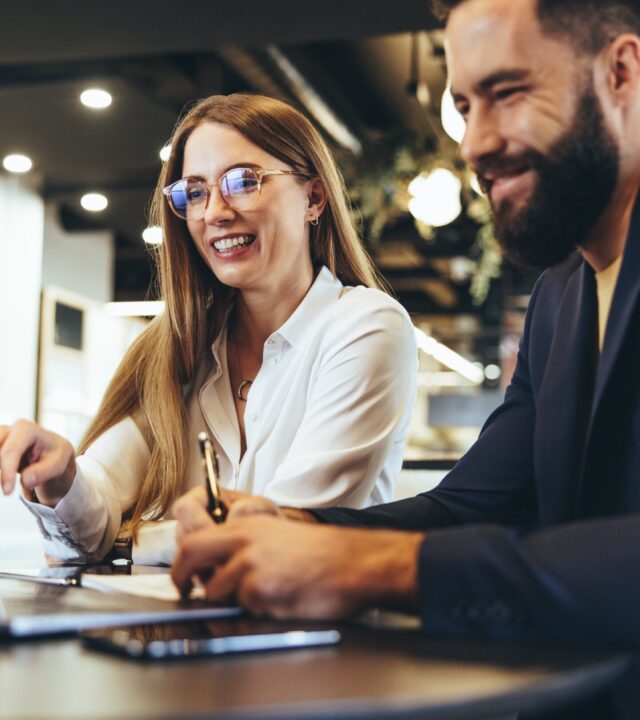 Cheerful,Businesspeople,Using,A,Laptop,In,An,Office.,Happy,Young